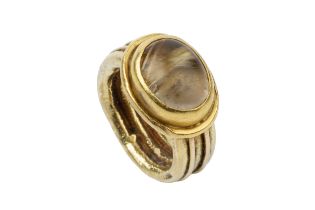 An 18ct gold and rutilated quartz set ring, the oval stone set in a heavy reeded setting and