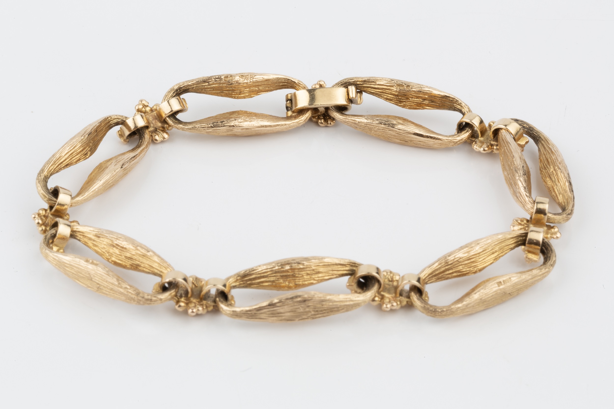 A 9ct gold bracelet, formed of shaped and textured elongated oval links with cluster spacers - Image 2 of 2