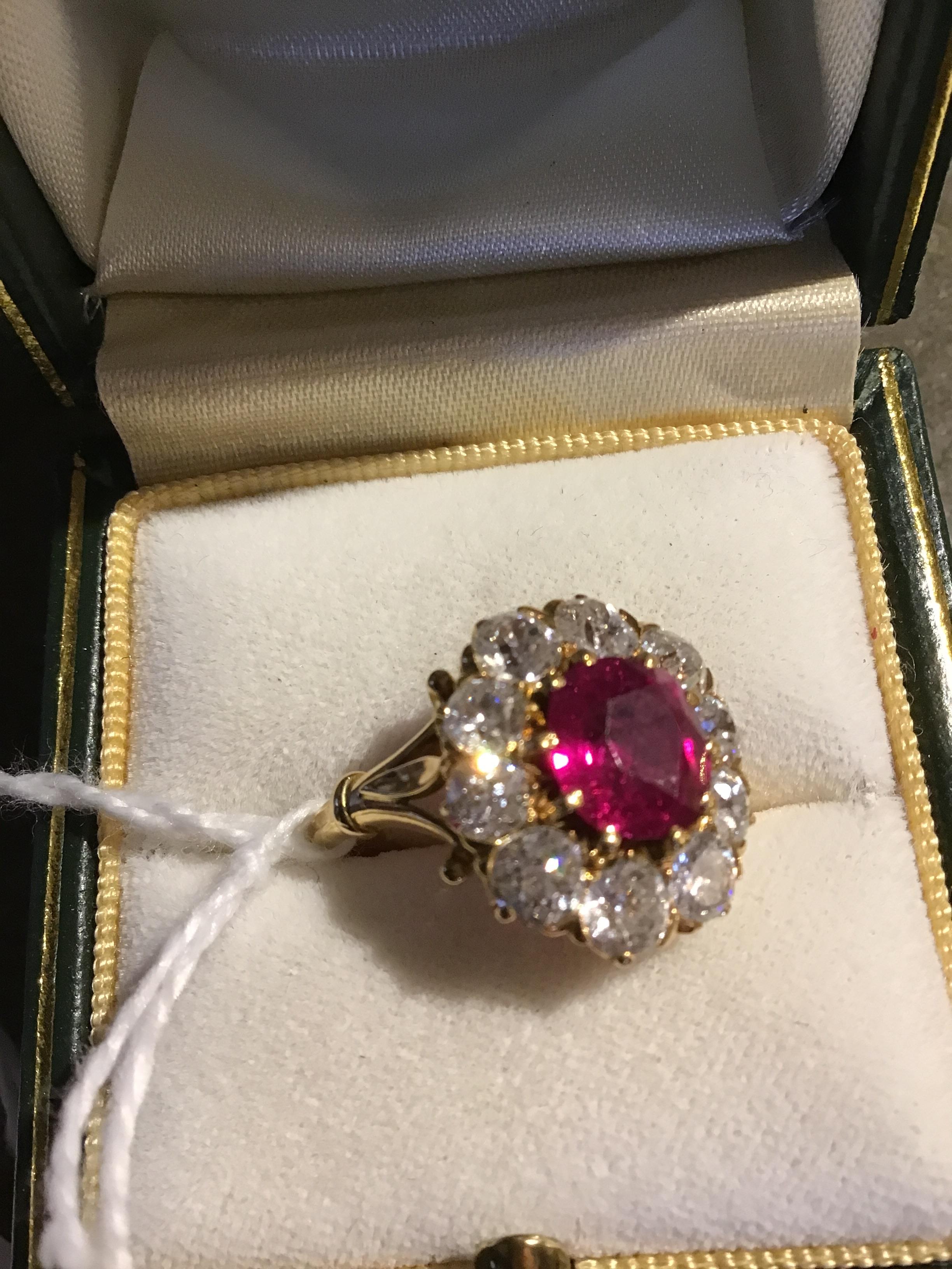 A ruby and diamond cluster ring, the central oval cut ruby within a border of ten old brilliant - Image 7 of 14