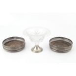 A pair of silver bottle coasters, with pierced decoration and turned hardwood bases, by Richards &