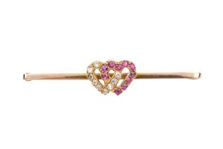 A 9ct gold diamond and ruby bar brooch, of entwined hearts design, one diamond set, the other with