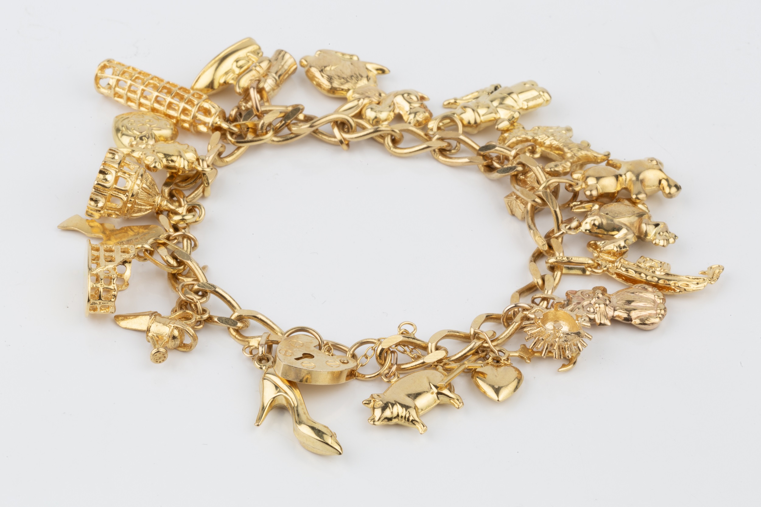 A 9ct gold curb link charm bracelet, with padlock clasp, hung with an assortment of charms approx - Image 2 of 2