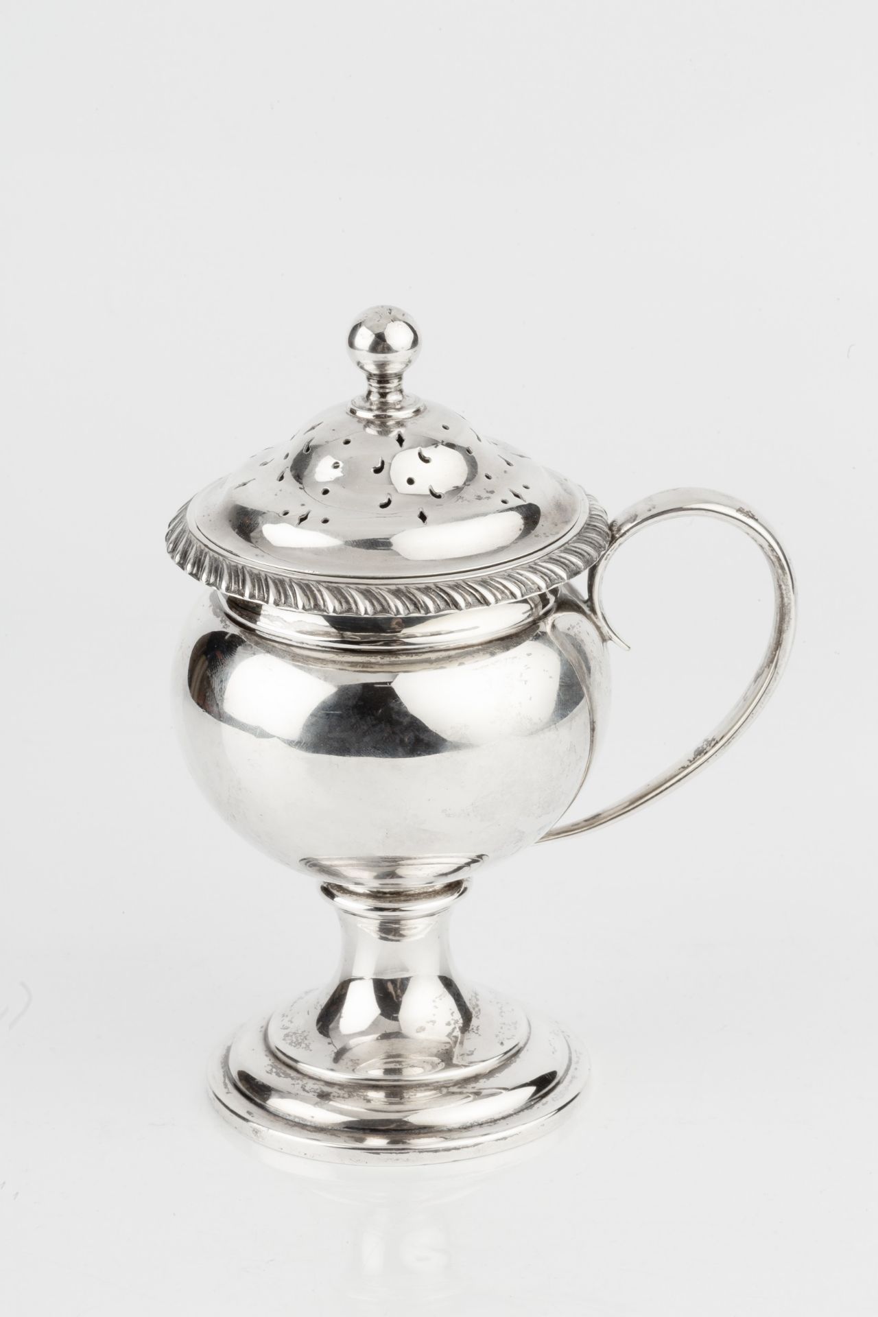 A George V silver sugar sifter, with gadrooned border, rounded body, side handle and circular - Bild 2 aus 4
