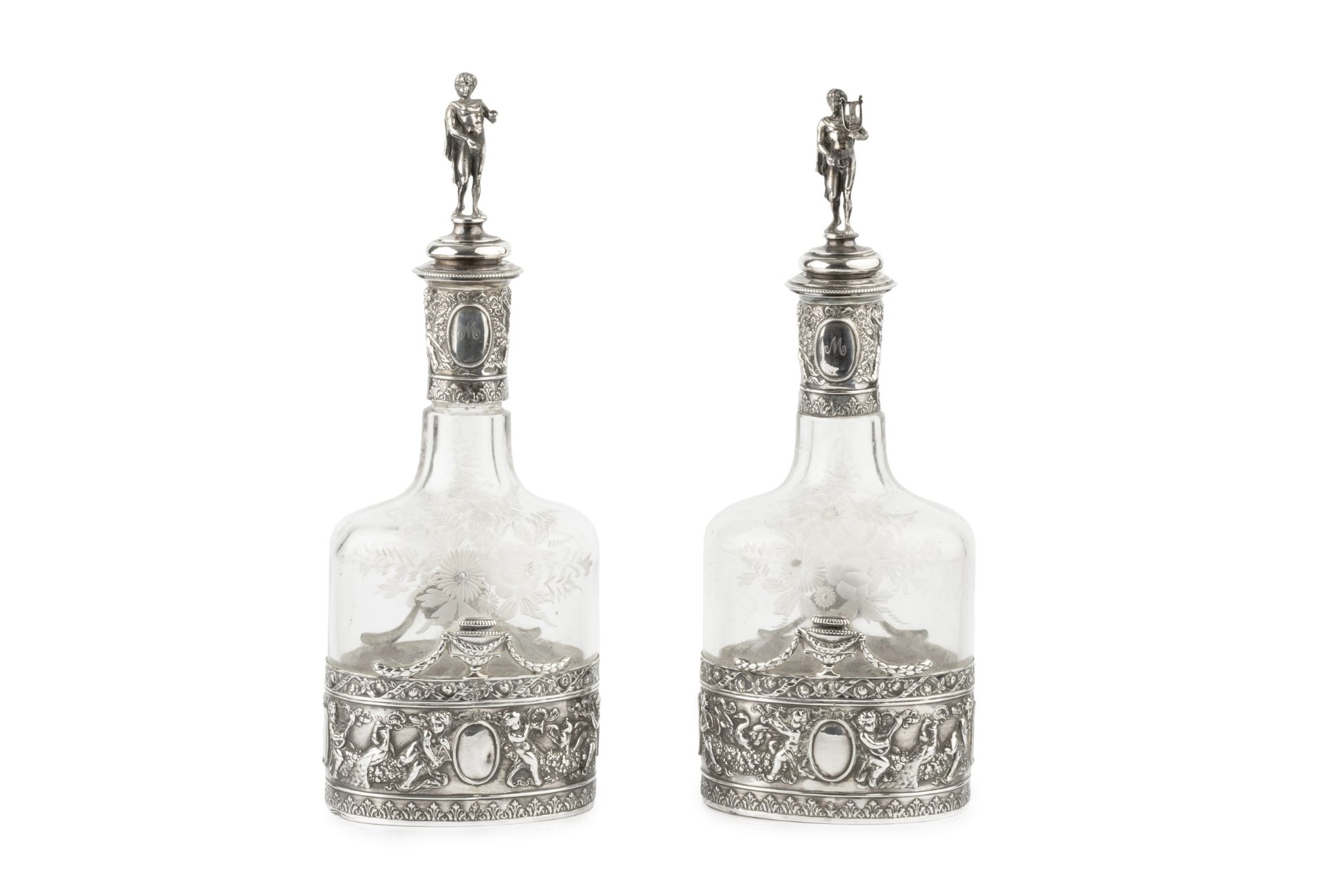 A pair of early 20th century Hanau silver mounted decanters and stoppers, repoussé decorated with