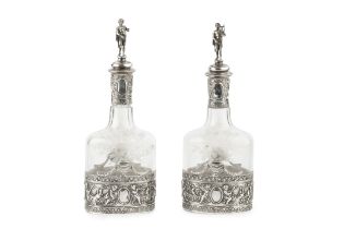 A pair of early 20th century Hanau silver mounted decanters and stoppers, repoussé decorated with