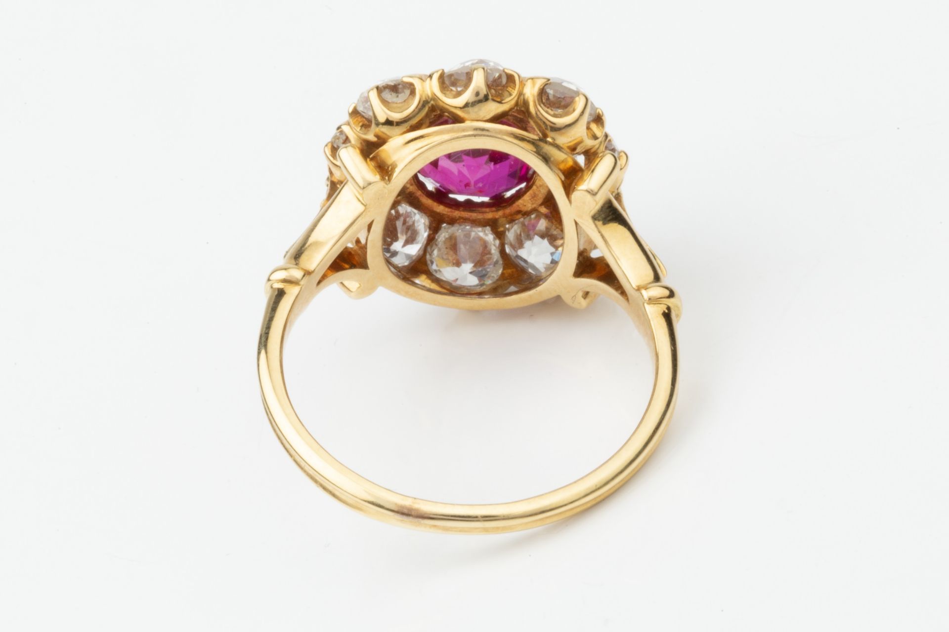 A ruby and diamond cluster ring, the central oval cut ruby within a border of ten old brilliant - Image 2 of 14