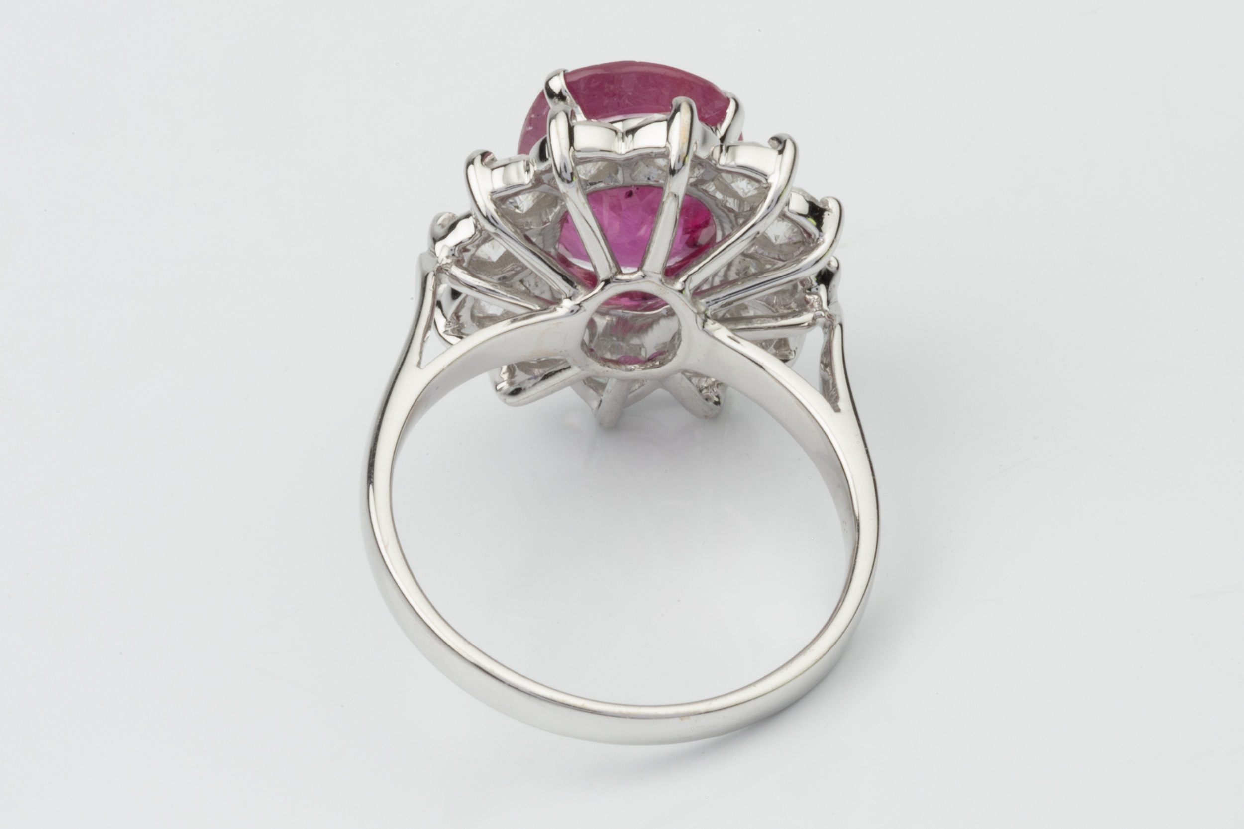 A ruby and diamond cluster ring, the oval mixed cut ruby within a border of twelve round brilliant - Image 2 of 4