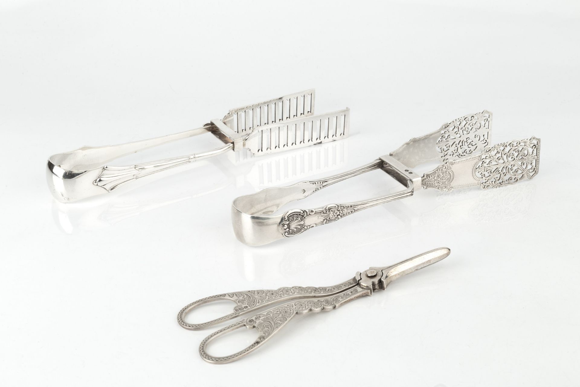 A pair of late Victorian silver King's pattern asparagus tongs, with shaped, pierced and engraved
