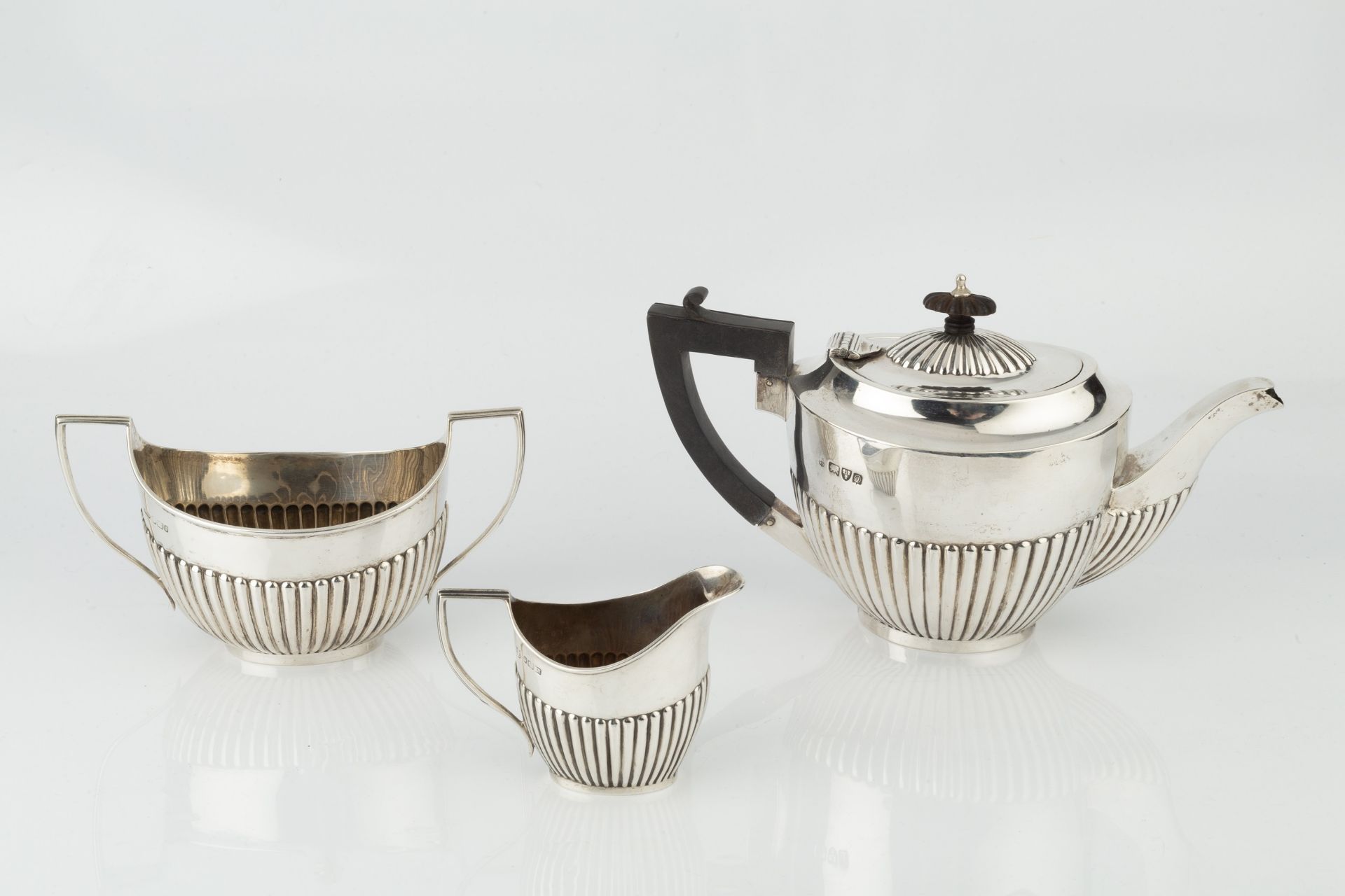 A matched silver three piece tea service, of half lobed form, the teapot with ebonised handle and - Bild 2 aus 2