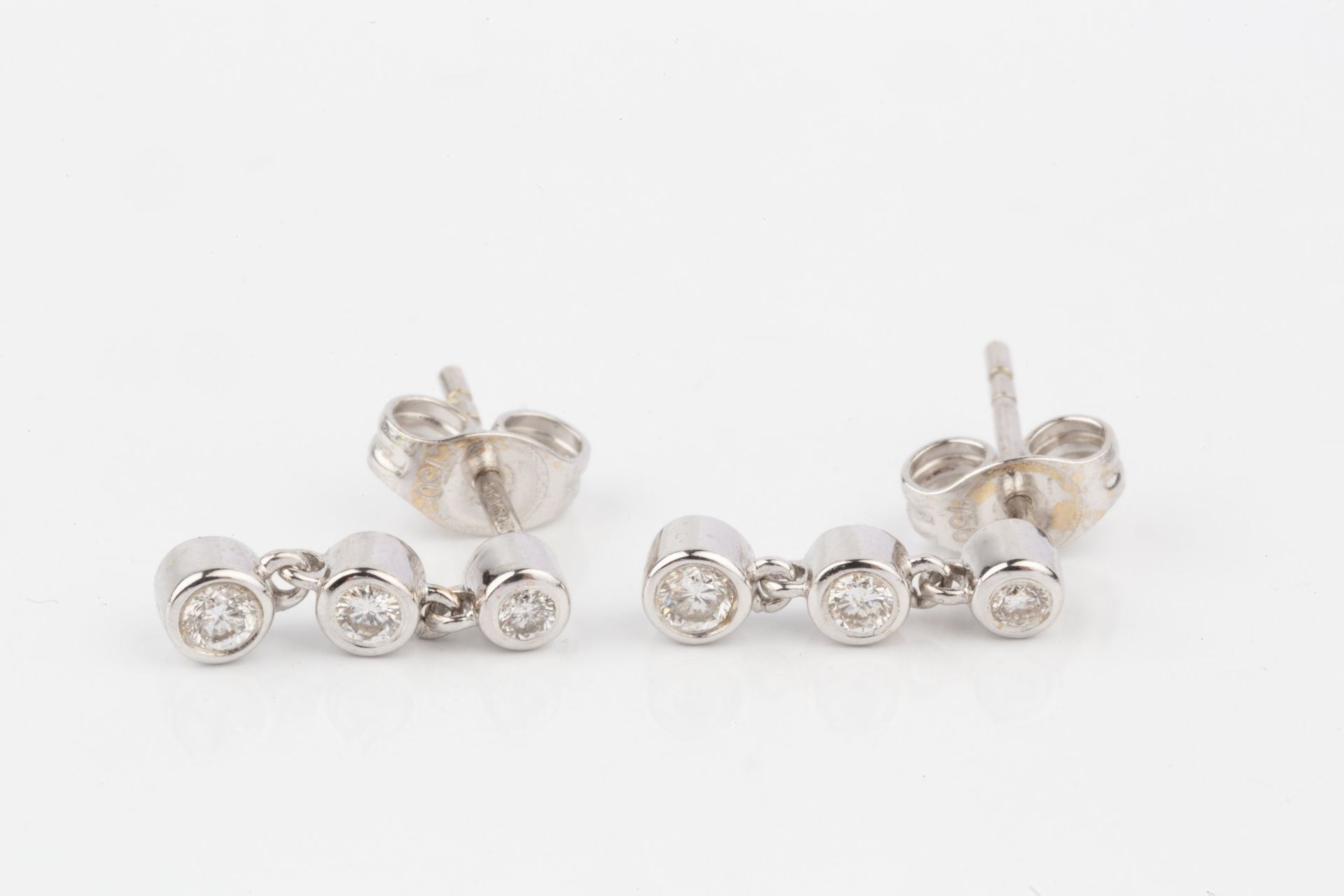 A pair of 18ct white gold and diamond earrings, each with three collet-set brilliant cut stones - Bild 3 aus 4