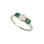 A diamond and emerald three stone ring, the central old-cut diamond in claw setting, between two