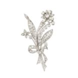 A diamond spray brooch, in the form of ribbon tied flowers and leaves, the main flower head set with