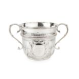 A late Victorian silver twin handled oversized porringer, the girdled body with spirally lobed lower