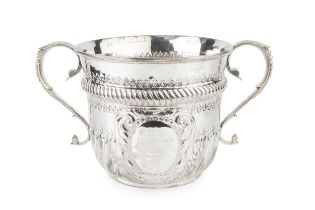 A late Victorian silver twin handled oversized porringer, the girdled body with spirally lobed lower