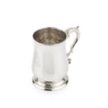 A George III silver pint mug, of baluster form, with leaf capped scroll handle and engraved coat