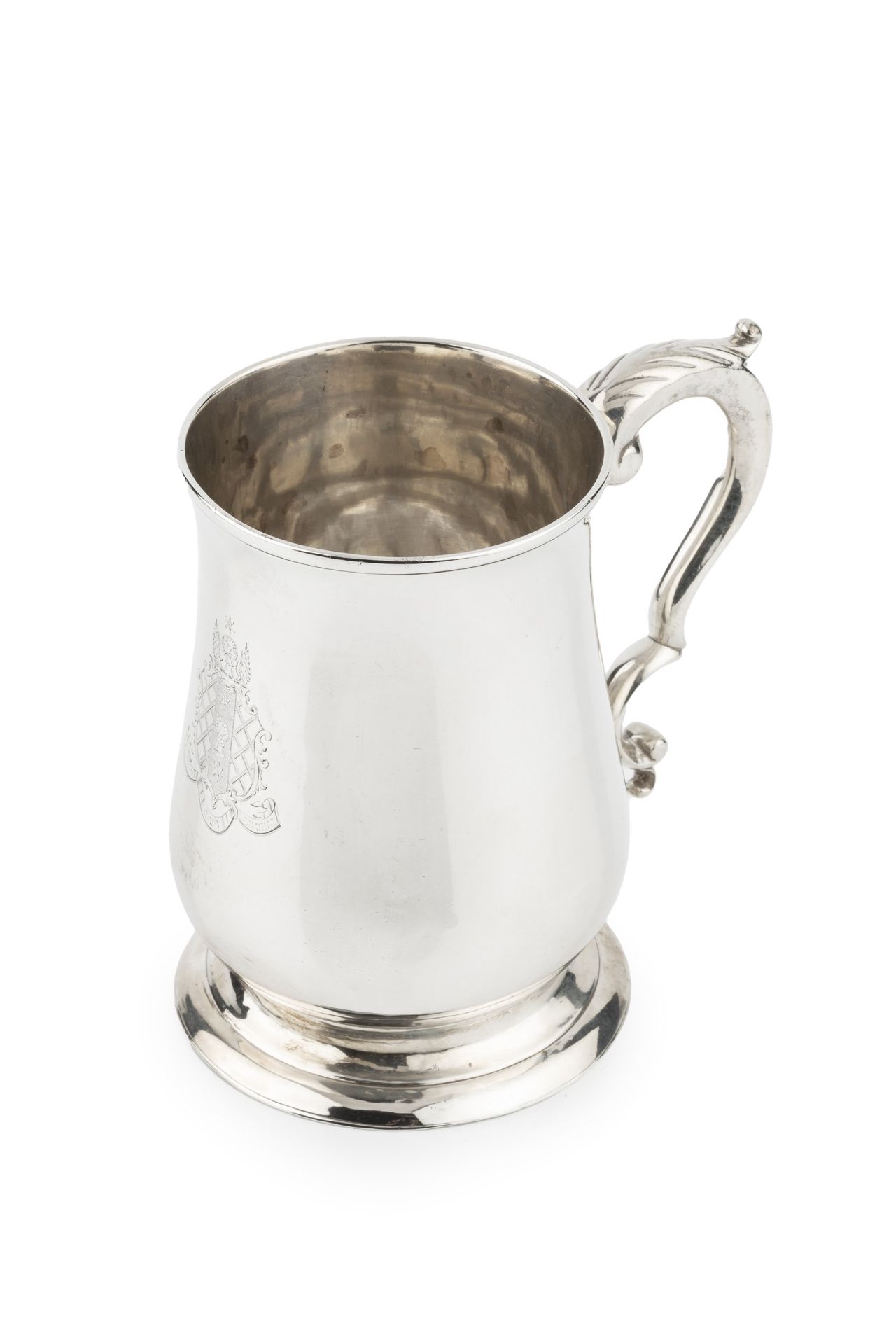 A George III silver pint mug, of baluster form, with leaf capped scroll handle and engraved coat