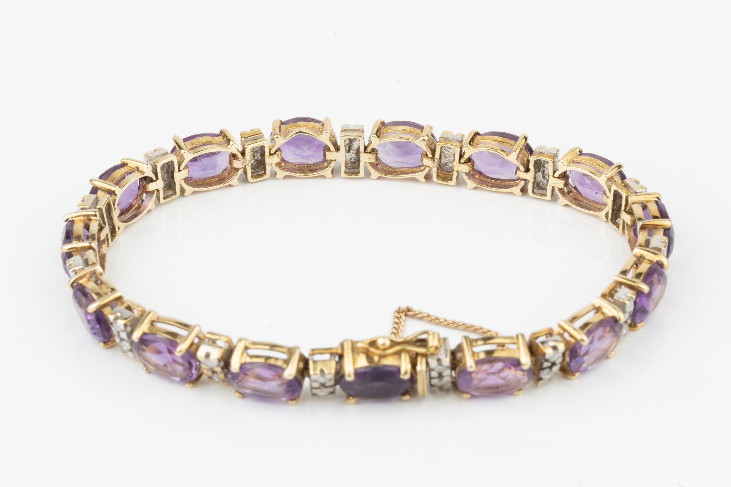 An amethyst and diamond bracelet, set with oval cut amethysts and having spacer bars between set - Image 2 of 2