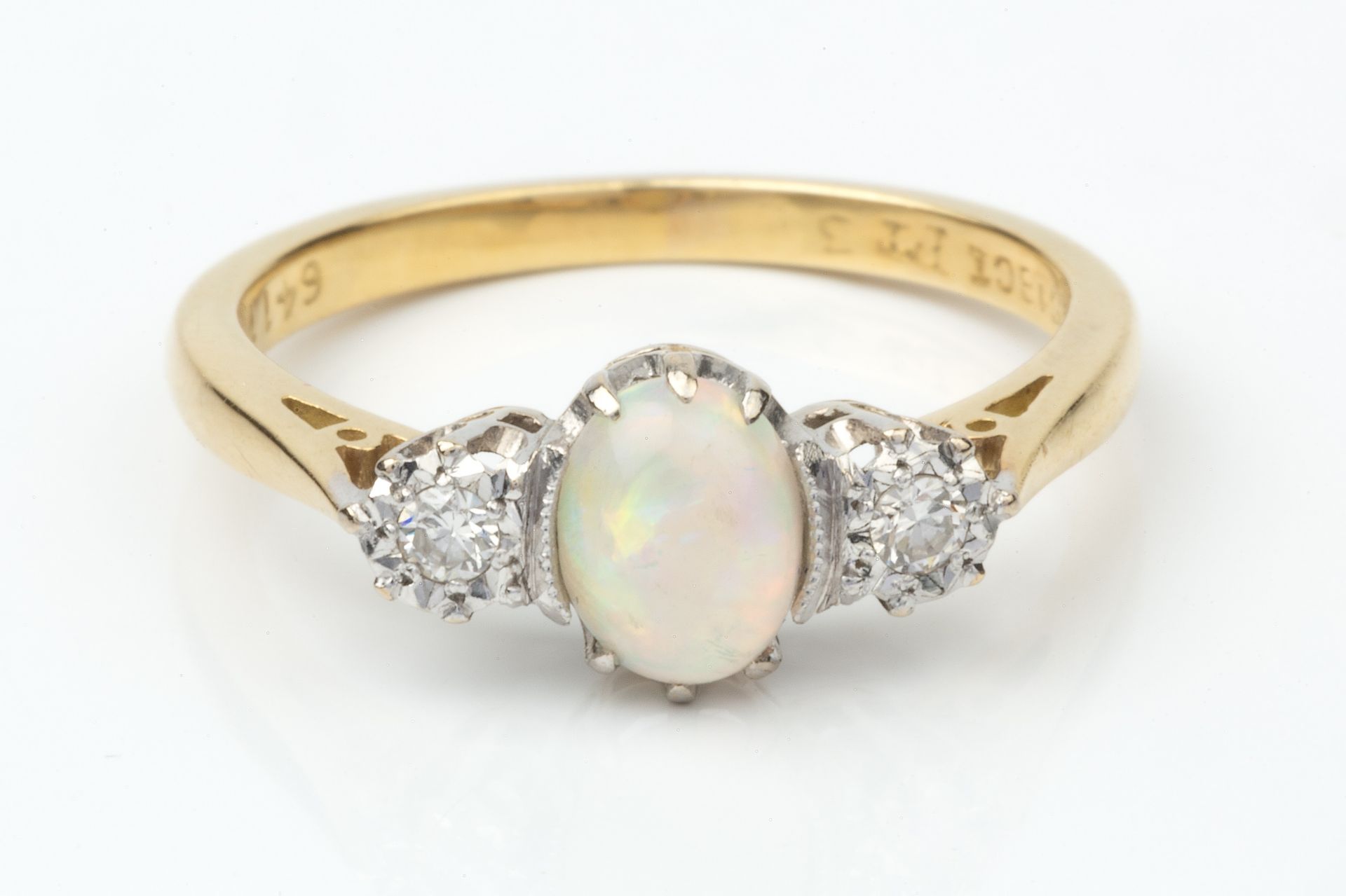 An opal and diamond three stone ring, the central oval cabochon opal flanked by a pair of small - Image 3 of 4