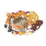 A collection of bead necklaces, comprising an amber bead example, various simulated amber, hardstone