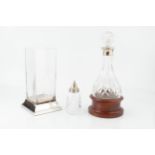 A silver mounted cut glass decanter and stopper, with rounded base and turned wooden stand, by