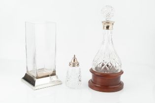 A silver mounted cut glass decanter and stopper, with rounded base and turned wooden stand, by