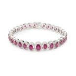 A ruby and diamond cluster line bracelet, composed of thirty one graduated oval cut rubies, each