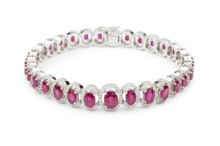 A ruby and diamond cluster line bracelet, composed of thirty one graduated oval cut rubies, each