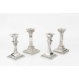 A pair of late Victorian silver candlesticks, of Corinthian form, with beaded drip trays and