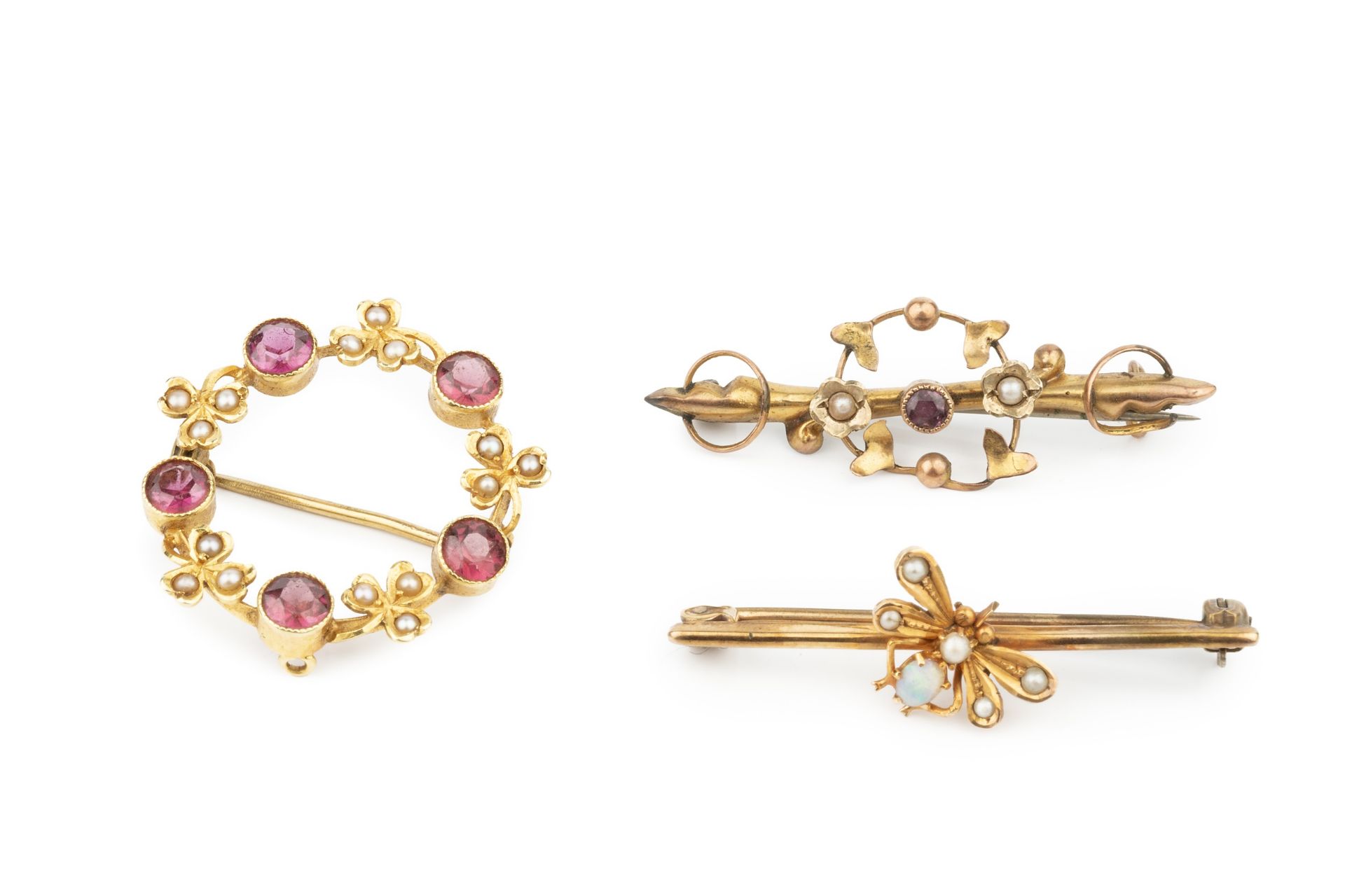 An Edwardian garnet and seed pearl set wreath brooch, the pink stones alternating with seed pearl