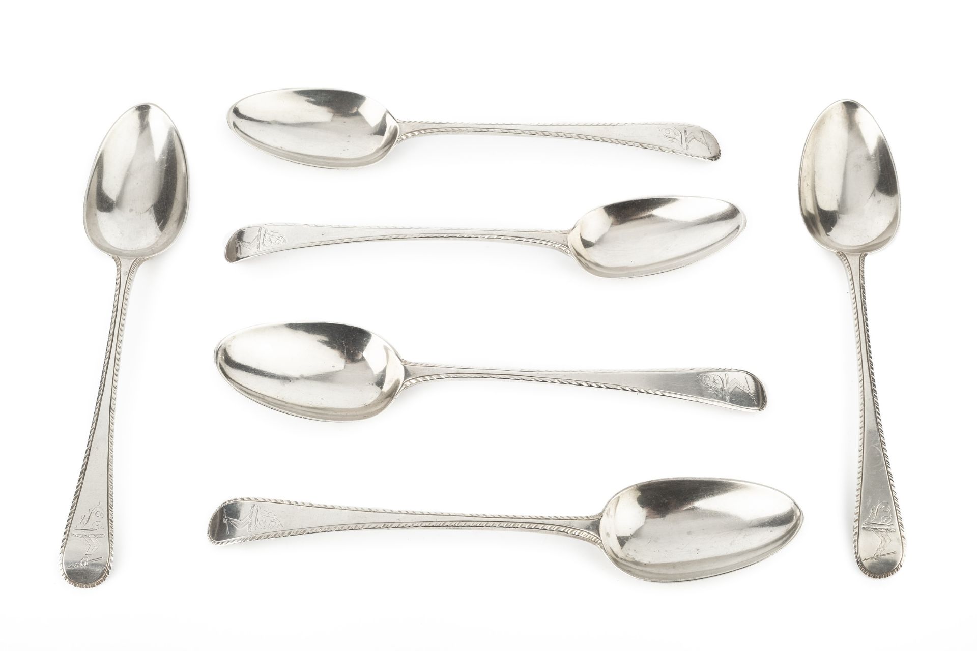 A matched set of six George III feather edged old English pattern table spoons, three with marks