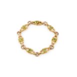 A 15ct gold and peridot bracelet, composed of shaped open ropetwist links, each centred with a round