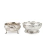 A late Victorian silver bowl, embossed and engraved with flowering foliage, on shaped legs with lily