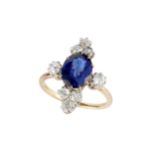 A sapphire and diamond dress ring, the oval cut sapphire claw set between two old brilliant cut