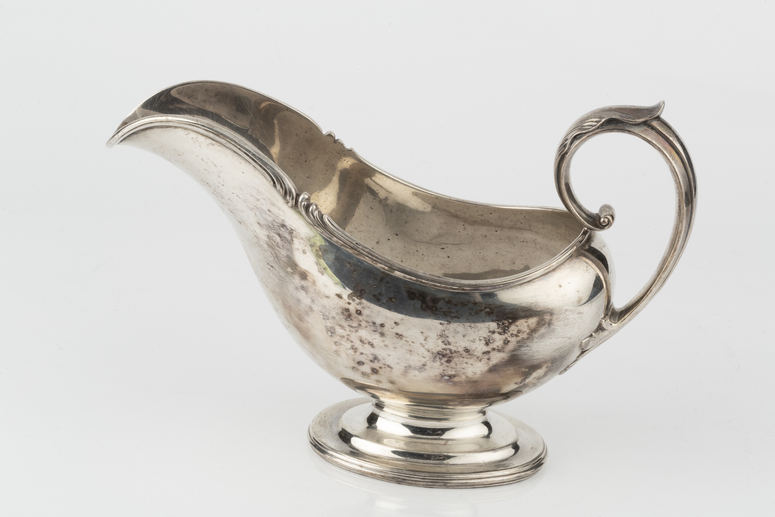 An American silver sauceboat, with shaped foliate cast border and leaf capped scroll handle, on oval - Image 3 of 3