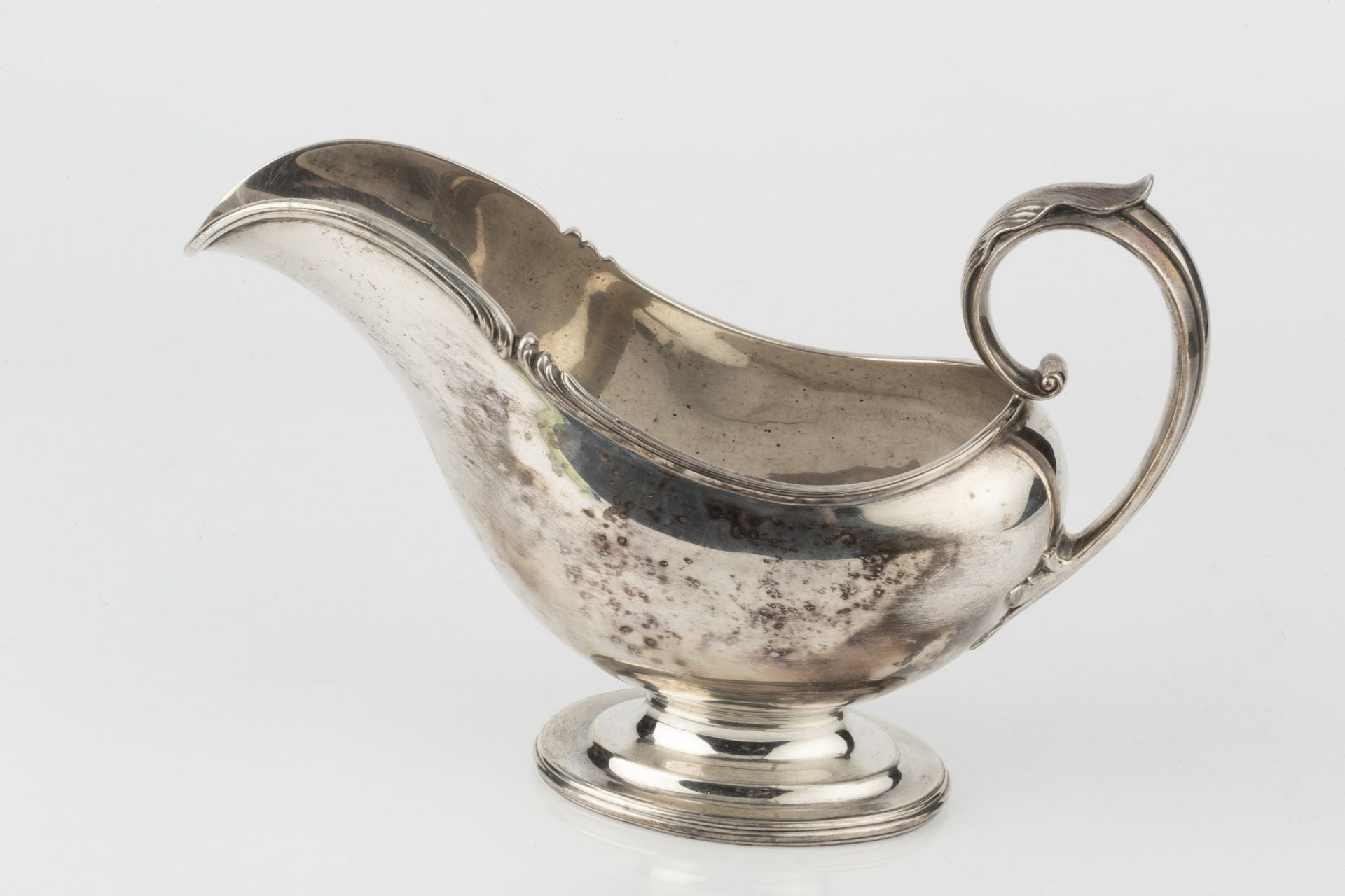 An American silver sauceboat, with shaped foliate cast border and leaf capped scroll handle, on oval - Bild 3 aus 3