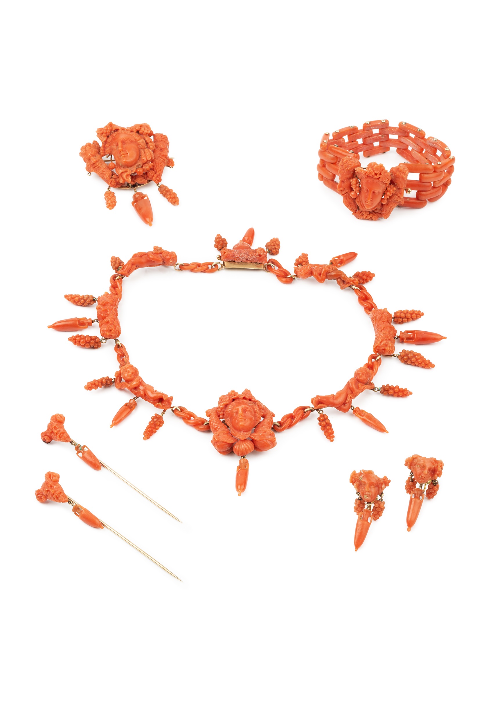 A suite of carved coral jewellery, comprising a necklace, bracelet, brooch, pair of earrings and two