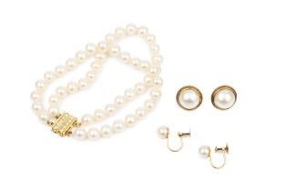 A twin strand uniform cultured pearl bracelet, the 18ct yellow gold clasp set with two lines of
