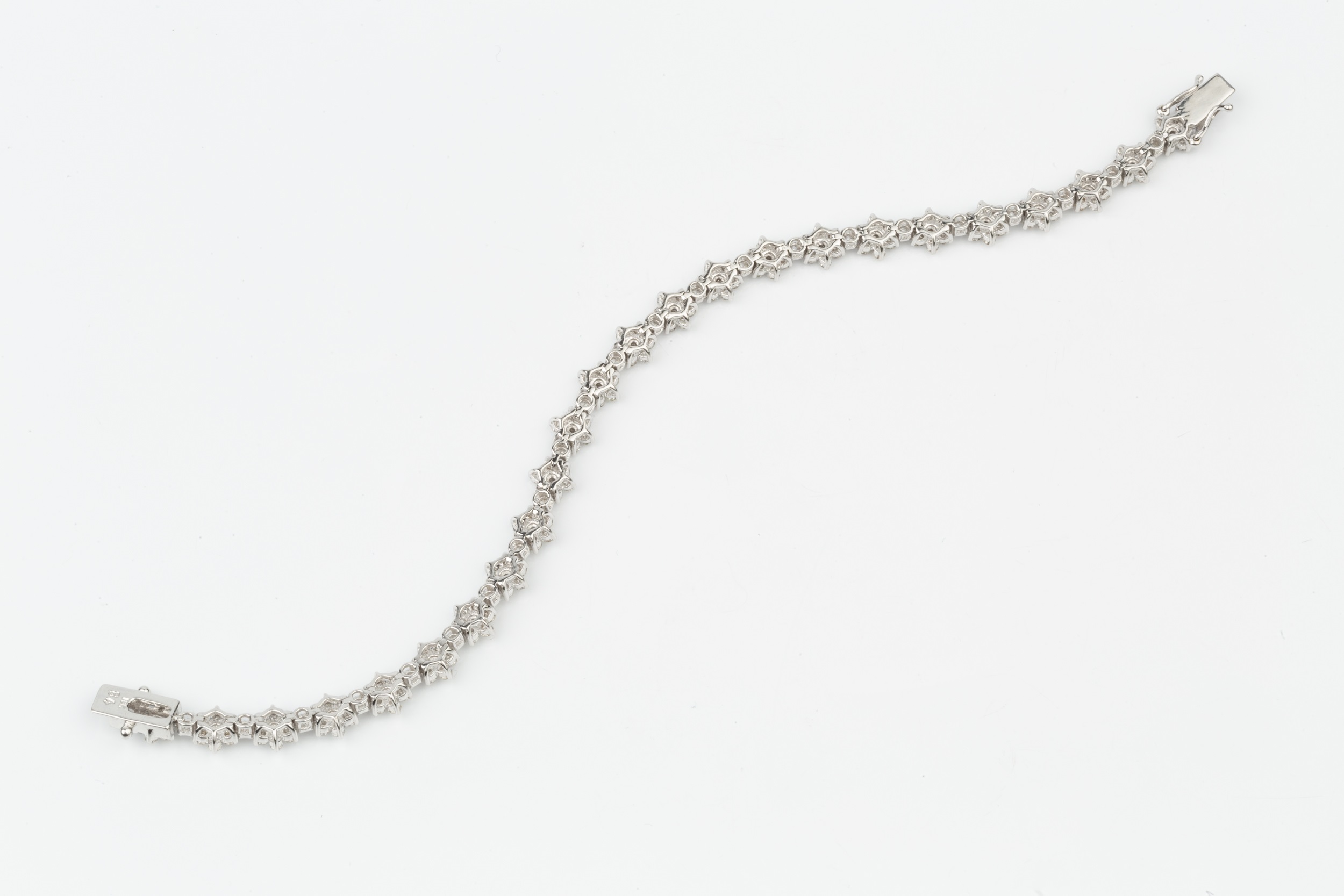 An 18ct white gold and diamond bracelet, set with a line of brilliant cut flowerhead clusters with - Image 3 of 3