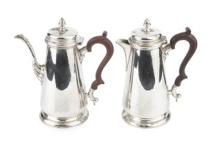 A silver coffee pot and matching hot water pot, with tapering baluster bodies, hinged covers and