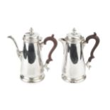 A silver coffee pot and matching hot water pot, with tapering baluster bodies, hinged covers and