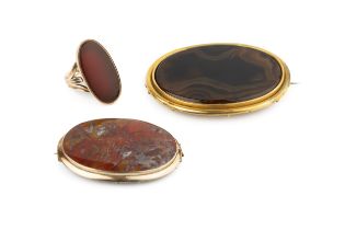 A 9ct gold and hardstone dress ring, the oval plaque approx 3.1cm high, the gold mounts with foliate