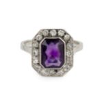 An amethyst and diamond cluster ring, the chamfered rectangular cut amethyst within a border of