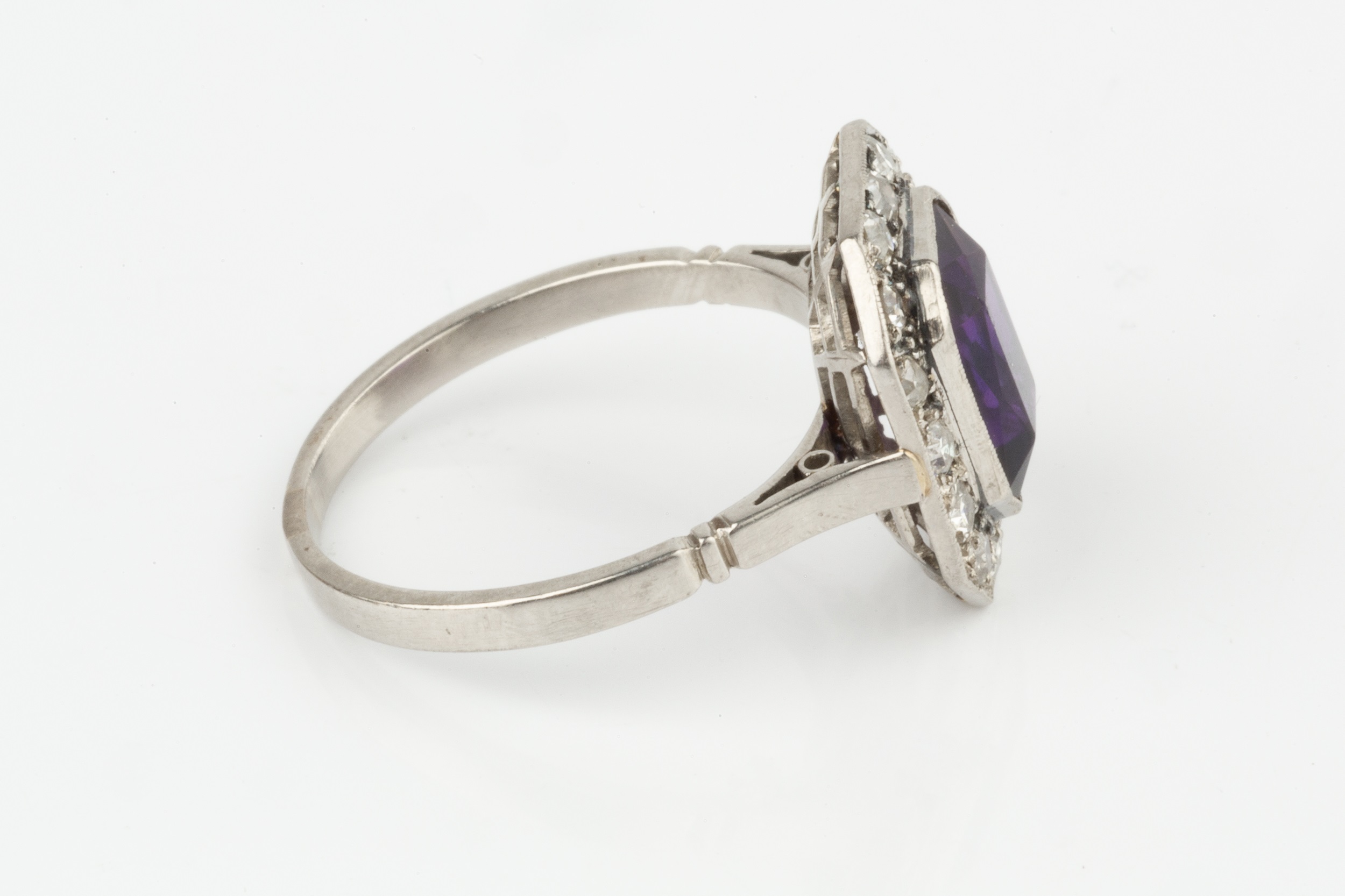 An amethyst and diamond cluster ring, the chamfered rectangular cut amethyst within a border of - Image 2 of 3