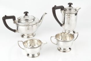 A George V silver four piece tea service, with gadrooned borders, the teapot and hot water pot