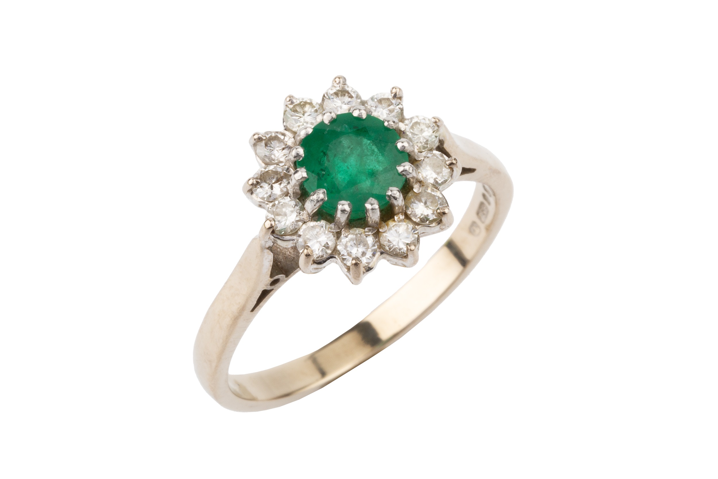 An emerald and diamond cluster ring, the central circular emerald within a border of twelve