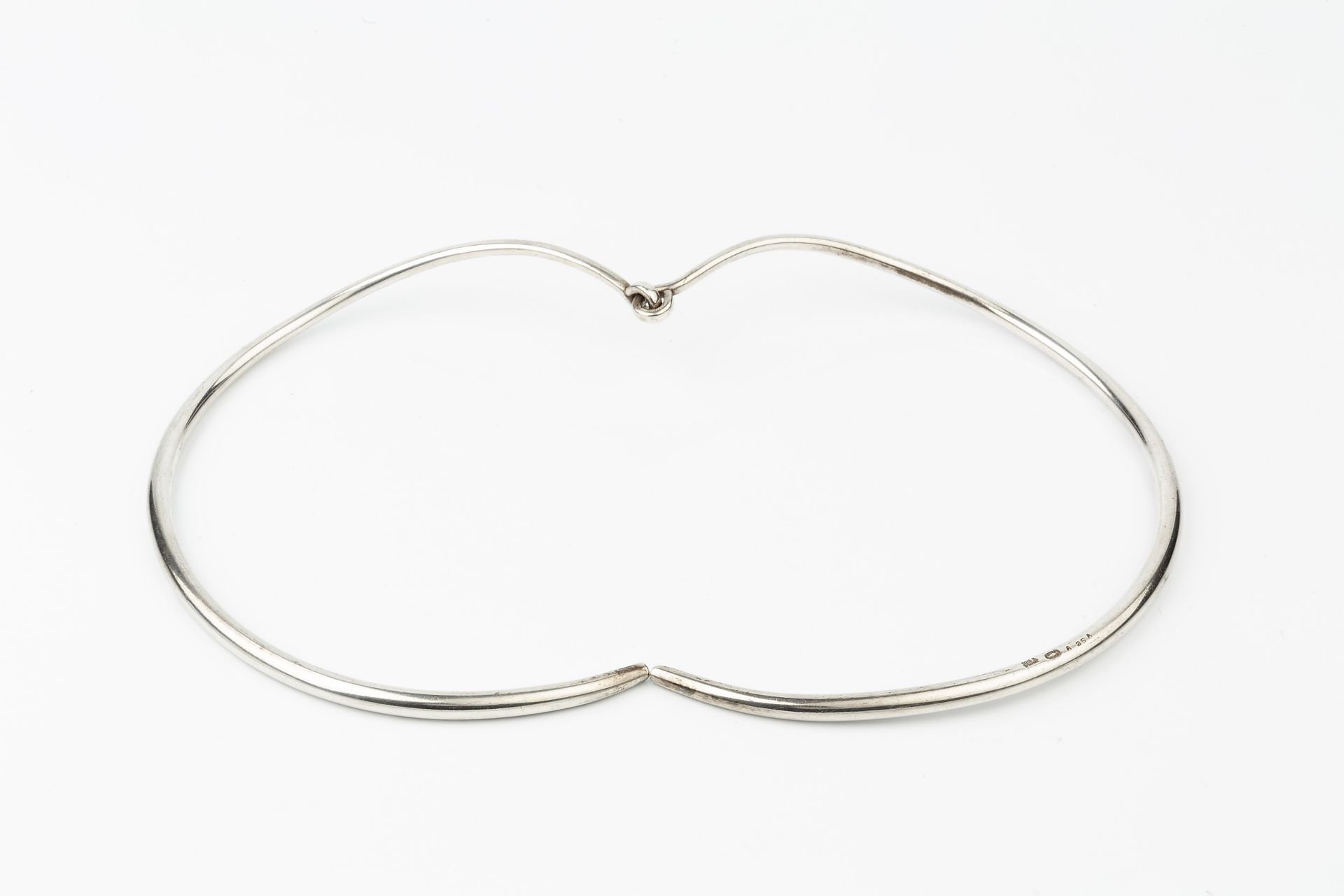 A Danish silver necklet by Georg Jensen, formed of two plain curved sections with loop hinge, no. - Bild 2 aus 3