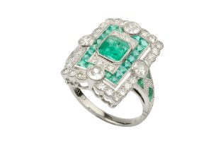An emerald and diamond panel ring, centred with an octagonal cut emerald bordered with mixed cut