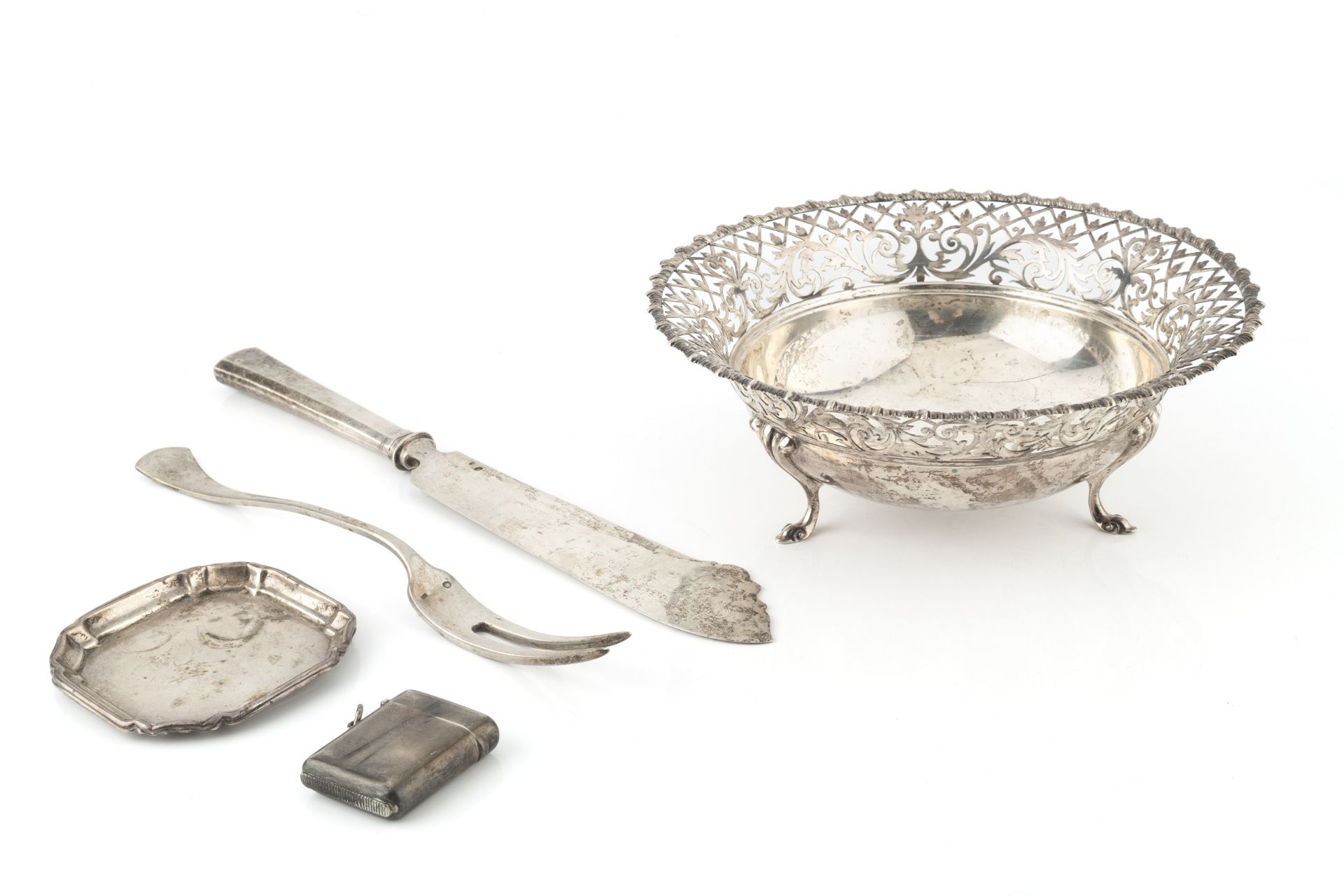 A George V silver circular dish, with scrolling foliate and trellis pierced border, on three