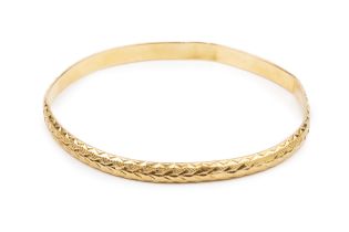 A yellow precious metal bangle, with engraved and textured decoration, 7cm wide approx 12.7g