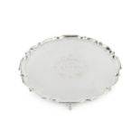 An Edwardian silver salver, with shaped border and pad feet, engraved presentation inscription, by